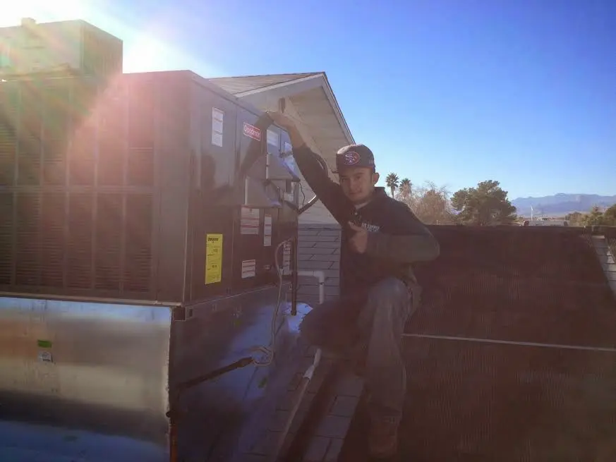 HVAC technician performing Boiler Repair on a rooftop unit in Litchfield