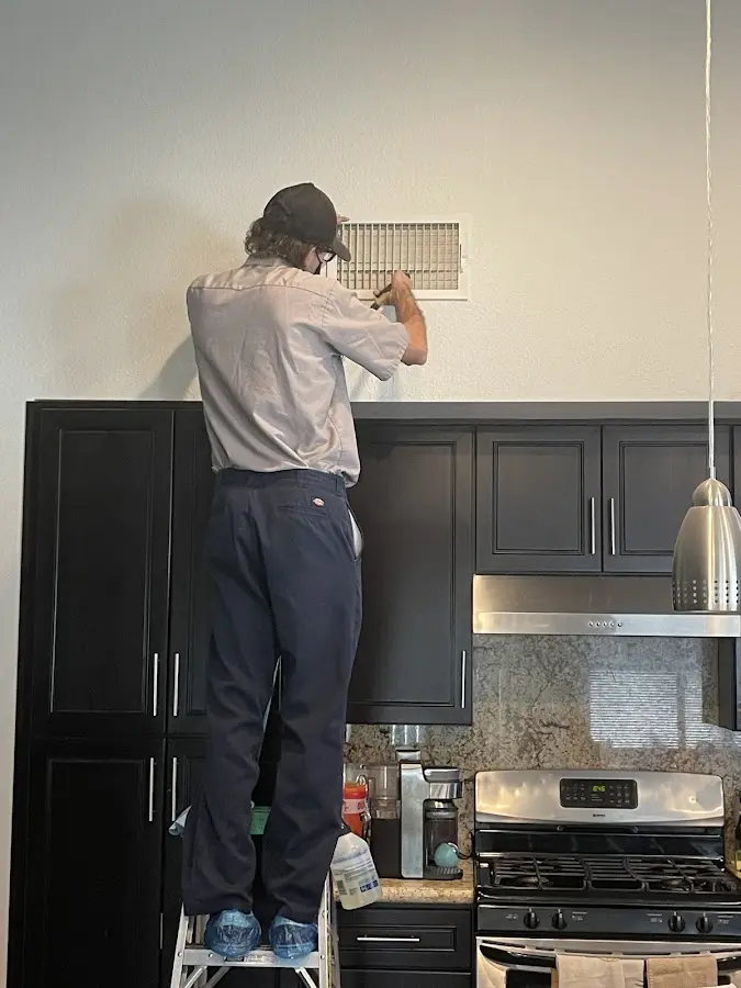 Technician inspecting an air vent during HVAC service in Litchfield
